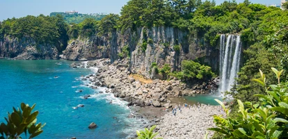 Jeongbang waterfall by pebble beach in Jeju Island in South Korea