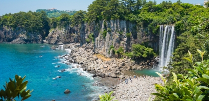 Jeongbang waterfall by pebble beach in Jeju Island in South Korea