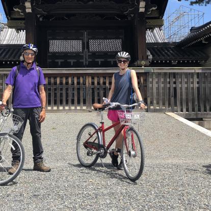 Three cyclists pausing for a photograph outside shrine