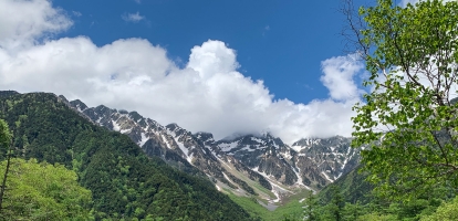 Snow-capped mountains are surrounded by beautiful forest in the valley of Kamikochi, central Japanese alps