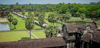Tourists walk along palm trees in the temple complex of Angkor Wat