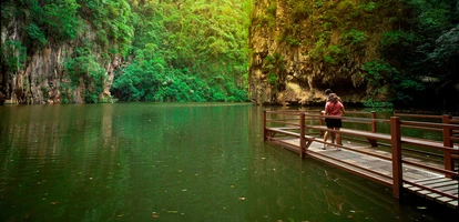 Two tourists admire the tranquil waters of Mirror Lake in Ipoh, Malaysia