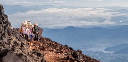 Pilgrims with traditional hats walking on Mount Fuji