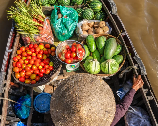 Lady transporting fruit on a boat on the Mekong Delta