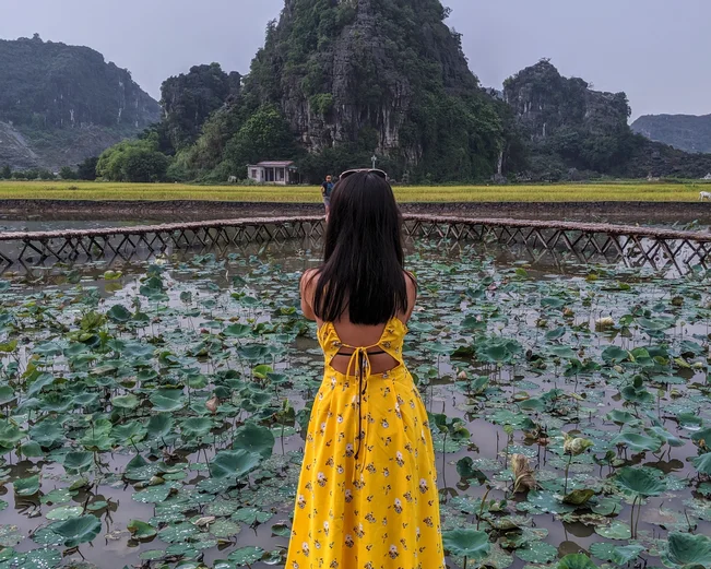 Girl in yellow dress taking photograph in Ninh Binh