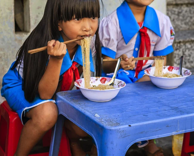 Vietnamese schoolgirls eating pho in Hanoi