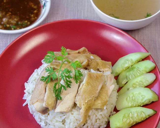 Hainanese chicken and rice with cucumber garnish 
