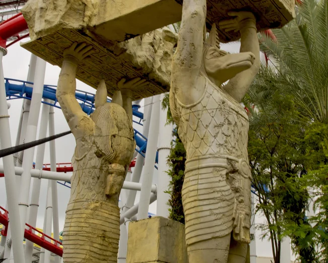 Stone statues in front of rollercoaster at Sentosa Island 