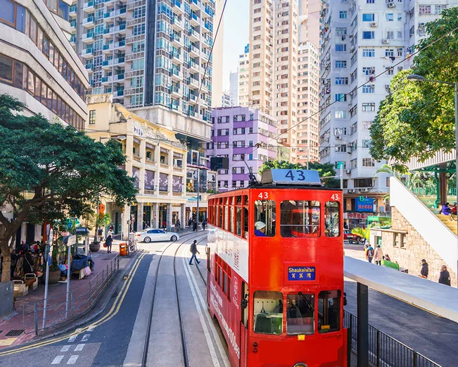 Red tram surrounded by skyscrapers 