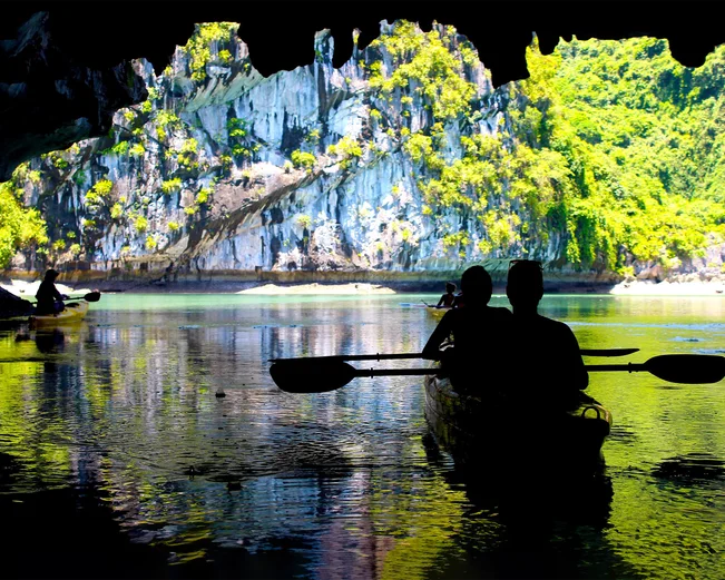 Silhouettes kayaking in Lan Ha Bay, with amazing karst rock background