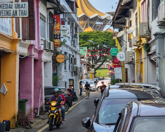A colourful street in Kuching with a temple in the background