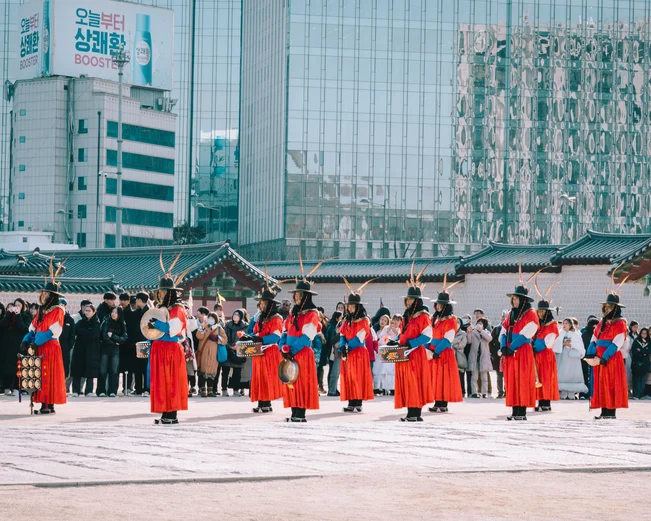Changing of the guard ceremony in Seoul Palace in front of modern skyscraper buildings