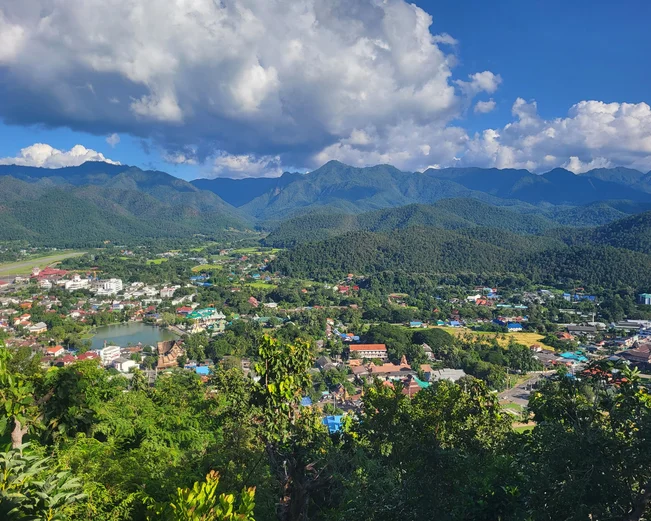 Elevated view of a town situated between green mountains