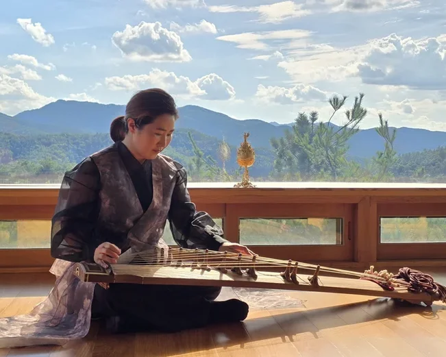 Korean woman playing traditional Korean instrument