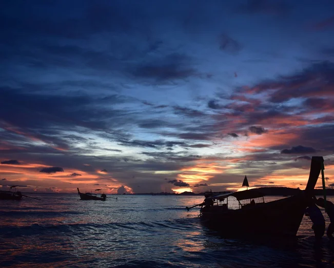 Krabi beach at sunset with a longtail boat