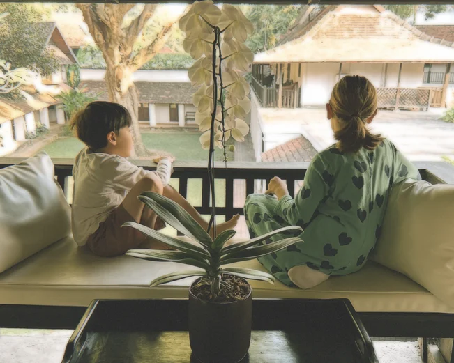 children sitting on a balcony in a Luang Prabang hotel