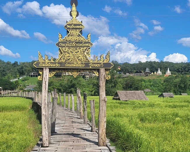 A Shan-style entry gate to a bamboo bridge over the rice paddies to a nearby monastery