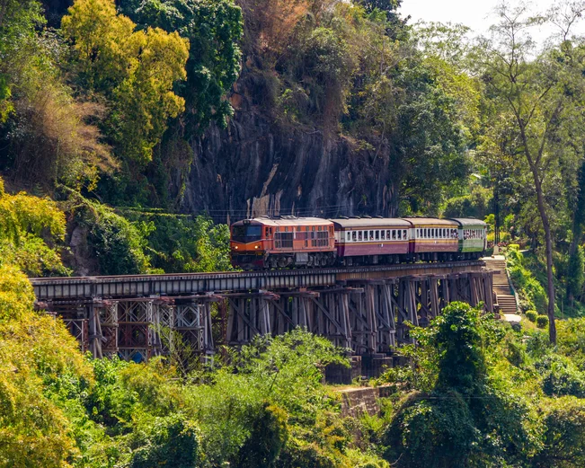 A train hugging the edge of a cliff in Kanchanaburi