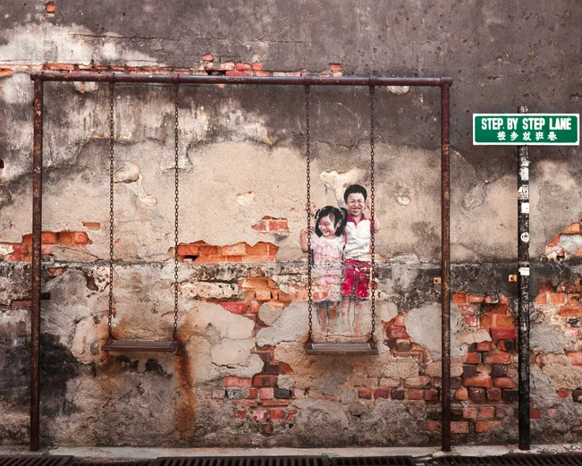 Street art piece of two children on a swing