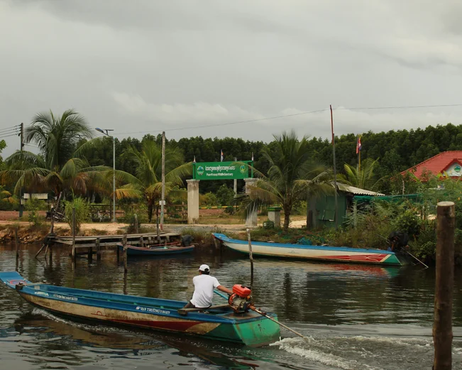 A longtail boat passes by an entry gate to a national park