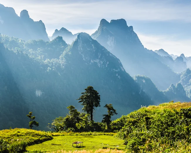 Mountain and blue sky at Kasi, Laos. and little home in grass field in front of mountain