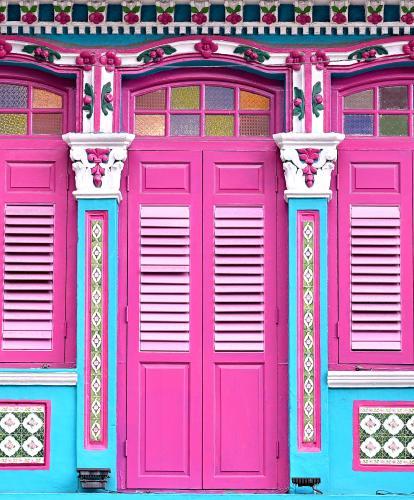 Bright pink doors and colourful trim on Peranakan building in Singapore