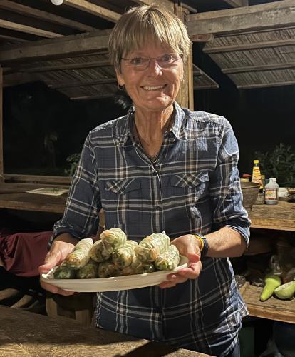 Tourist making summer rolls with local Laos family