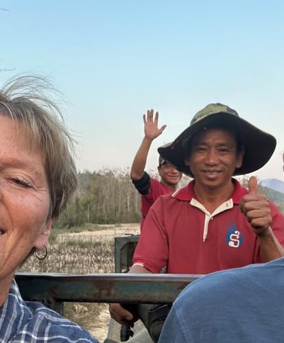 A tourist couple on a tractor in Laos with locals
