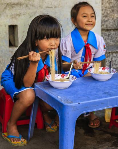 Vietnamese schoolgirls eating pho in Hanoi