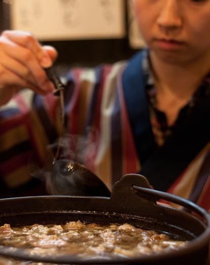 Lady eating Japanese food with chopsticks