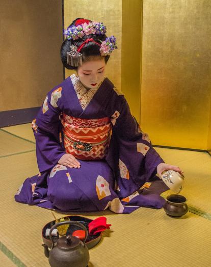 Maiko preparing tea in yellow room in Kyoto