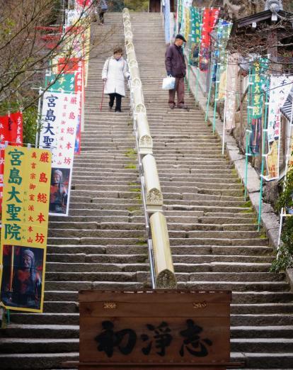Two people descending steps in Miyajima