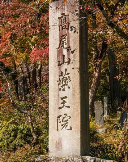 Stone column with Japanese text at the entrance of Mount Takao National Park