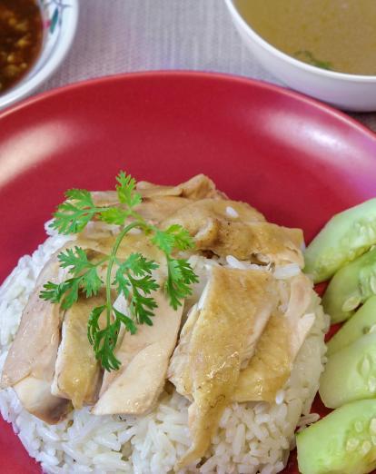 Hainanese chicken and rice with cucumber garnish