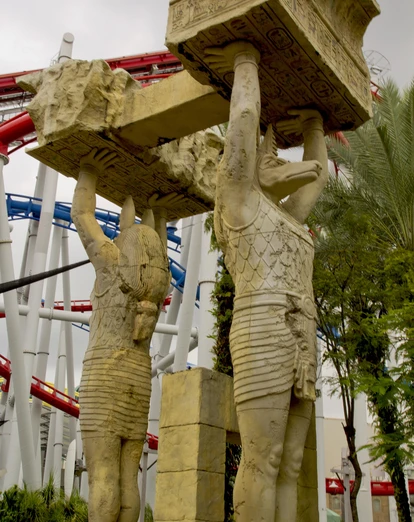 Stone statues in front of rollercoaster at Sentosa Island 