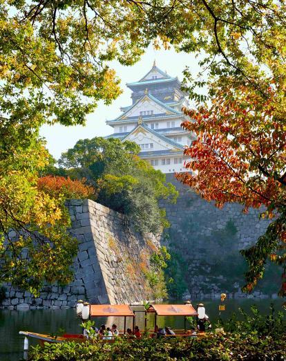 Osaka castle through the autumn trees 