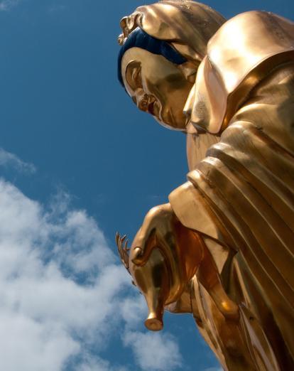 Golden Buddha statue with sky in background
