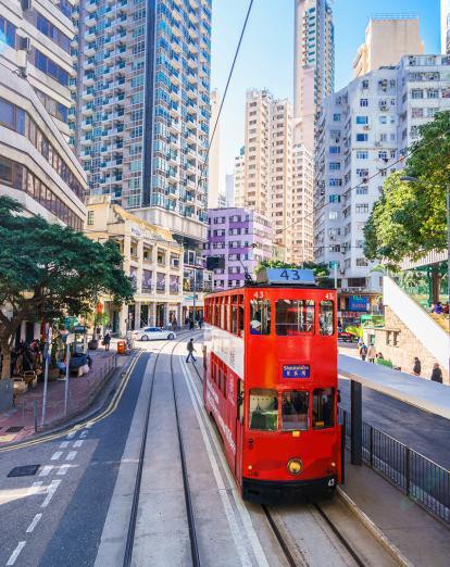 Red tram surrounded by skyscrapers