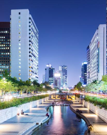 Cheonggyecheon stream in downtown Seoul at night with lights reflecting on the water