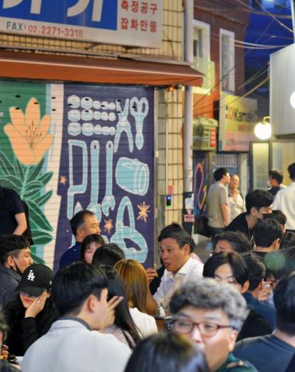 People gather in an urban open area in Seoul to eat at the Euljiro Night Market