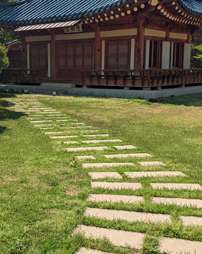 Traditional Korean building in Seoul, South Korea, surrounded by grass and a stone path
