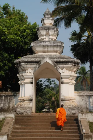 Monk walking up steps in Luang Prabang