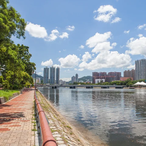 Path alongside waterfront with skyscrapers and city skyline in the background 