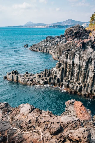 Top-down view over cliffs of Jeju Island above the sea in South Korea