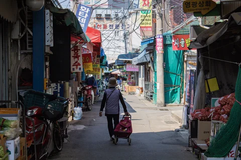 Woman walking down a street market in Seoul