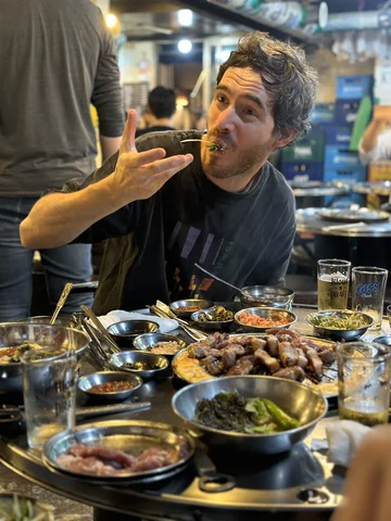 A tourist in South Korea trying traditional food on a Korean Wave itinerary
