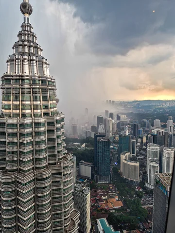 The view of a storm approaching the Petronas twin tower from the top of one in Malaysia