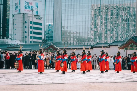 Changing of the guard ceremony in Seoul Palace in front of modern skyscraper buildings