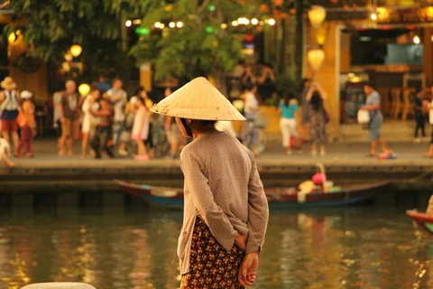 Local Vietnamese woman looking over the lantern lit river in Hoi An 