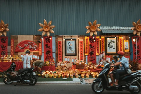 Locals on motorbikes whizzing past a store in Ho Chi Minh city during Tet celebrations